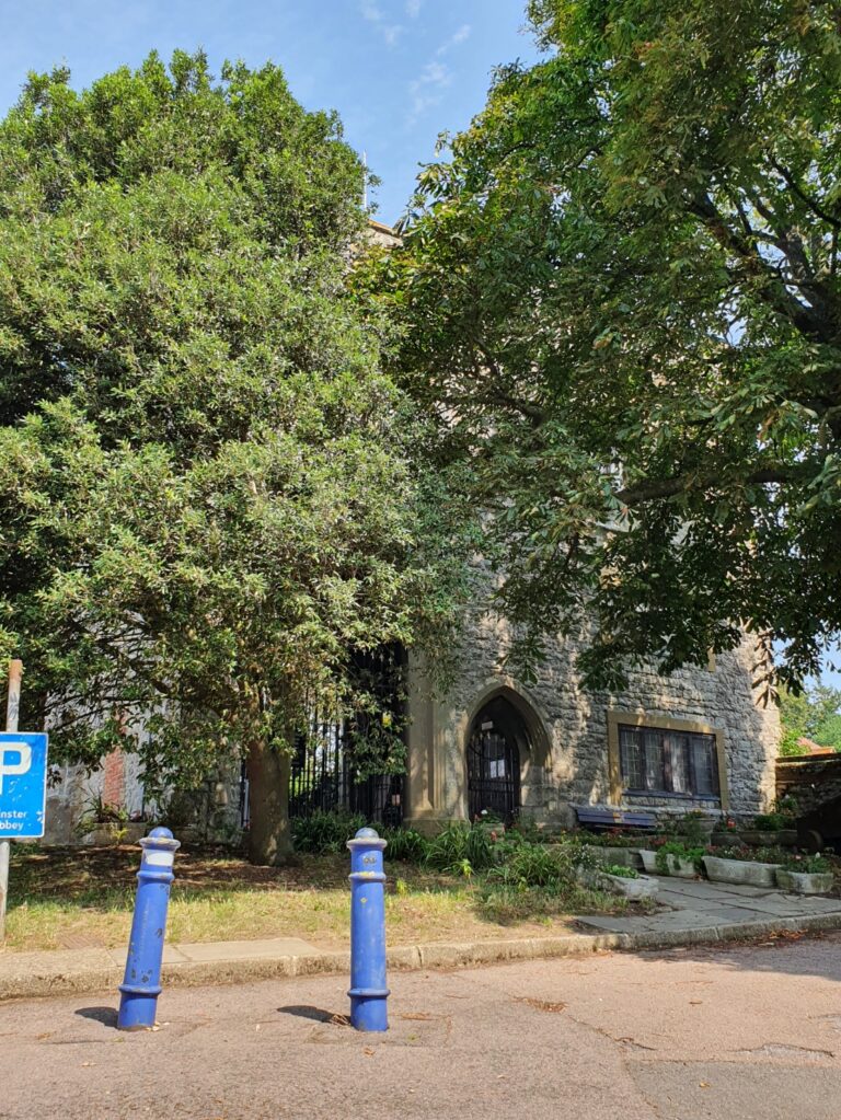 The front of the Gatehouse, the memorial garden and bench visible. A lovely shady place to sit and relax.